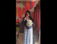 Girl puts white cat in sweater hood 