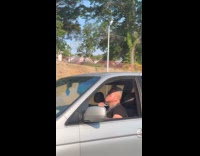 Man drive car and shave his neck