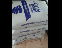 Puppy hide behind sacks of hardwood pellets