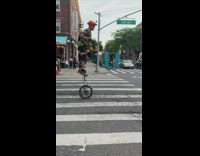 Guy rides unicycle down street in Queens 