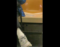 Man on his phone sitting next to seat filled with brown water 