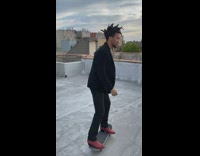 Guy skateboard kickflip red boots rooftop 