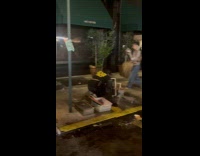 Guy washes tray using fire hydrant water