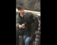 Girlfriend applies chapstick on boyfriends lips who tries to kiss her on subway
