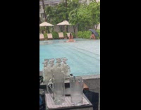 Woman in bikini sits and moves her butt at the poolside