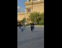 Two women tiktok dance while a man watches in front