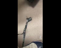 Guy reaches for lanyard in other bathroom stall