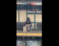 Woman sitting at train bench brushing teeth
