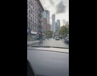 Guy stands rides bicycle seat handlebar street