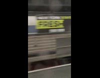 Shirtless guy figuring out umbrella with woman next to him