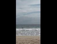 Woman in black bikini got hit by the beach waves