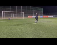 Goalie blocks ball and gets knocked down