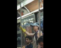 Woman wears yellow kitchen gloves while holding onto pole on subway train
