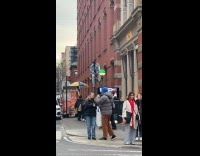 Man sits on top of street pole