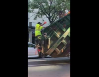 Guy dances garbage truck orange gloves headphones 