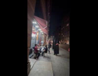 Person wearing zombie mask, cloak and stilts 