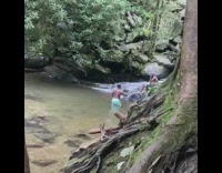 Blue shorts guy selfie stick waterfall rock 