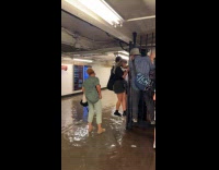 People climb fence to avoid subway flood