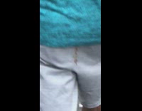 Guy has poop stain on back of pants while walking on sidewalk