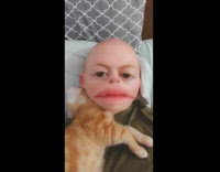 Guy lays in bed with cat filter