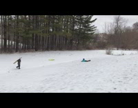 Kid chase sled slide down snow hill