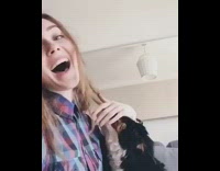 black dog chewing girls hair and sticking tongue out 