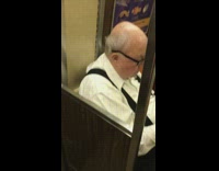 Old man has yellow scab fungus on top of bald head on subway train