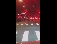 Shirtless guy grey shorts dances crosswalk night 