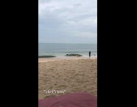 Woman yellow dress knocked by waves rock