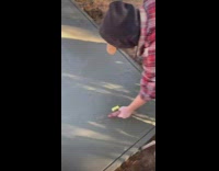 Guy smoothing cement friend throws lighter into his work 