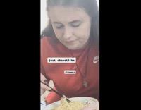 Red shirt girl attempts to use chopsticks 