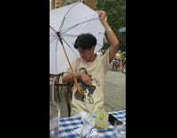 Two guys girl sit restaurant table umbrella 