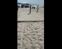 Woman in bikini lie down in front of tripod at the beach