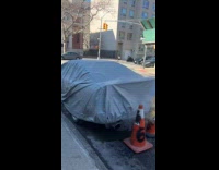 Car covered on street with smoking pipe