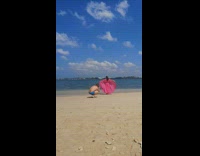 Woman lift skirt of pink dress beach