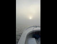 Filmer on boat sail through  fog weather