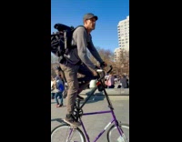 Man rides tall bike stroll at park