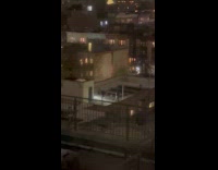 Two people dance with lights at rooftop