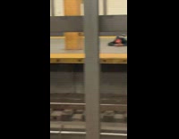 Man red hat sleeps on the ground and gets woken up by rat in subway station