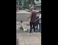Woman in cyan abstract outfit sits on the street