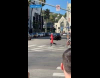 Person in red suit walks on crosswalk
