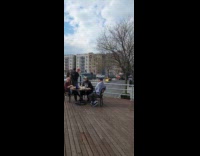 Men dine outside while trash burn street
