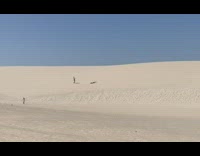 Girl roll down sand dunes sunny desert