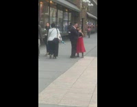 Woman in red long skirt walks and jumps on the sidewalk