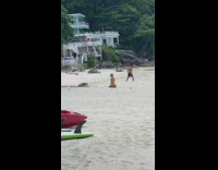 Woman in yellow bikini kneels on the beach