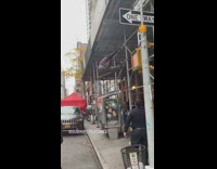 Brown jacket guy hangs on scaffolding bar