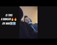 Two teenagers wearing hoodies record themselves rapping along to a rap song 