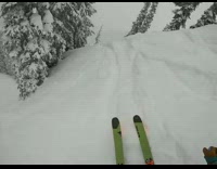 Guy green skis rides down steep mountain and jumps down slopes