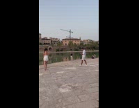Woman in white dress walks by the river