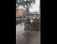 Black shirt guy restaurant patio table rain 